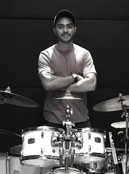 Bis Arun Drummer standing behind a drum kit