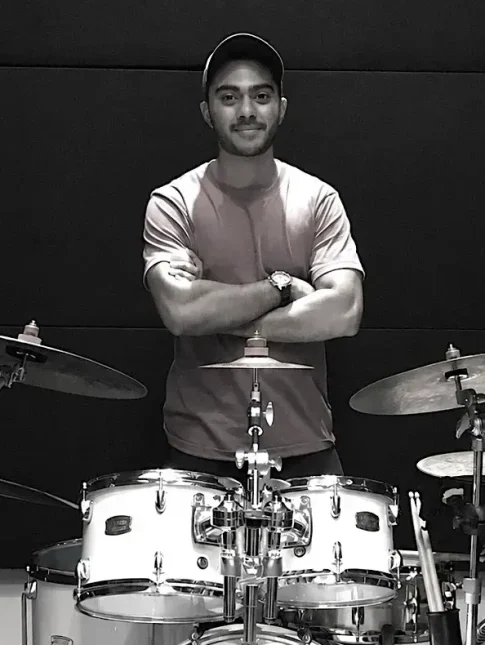 Bis Arun Drummer standing behind a drum kit